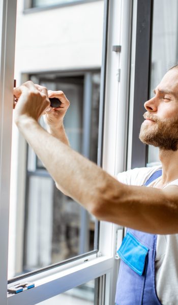 Workman adjusting window frames at home